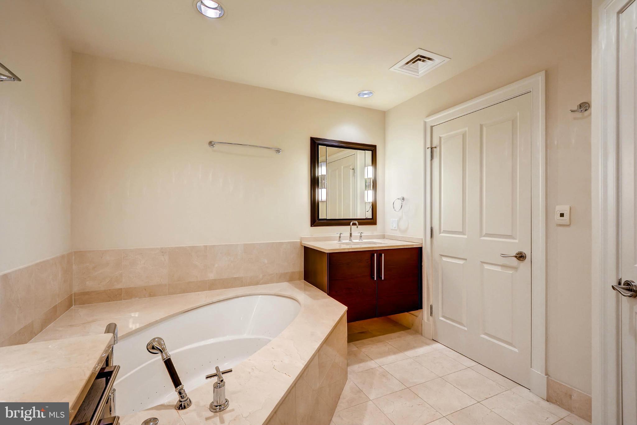 801 Key Highway, Unit 122 Baltimore, MD 21230 - Photo 20 of 30 a bathroom with a tub sink and mirror