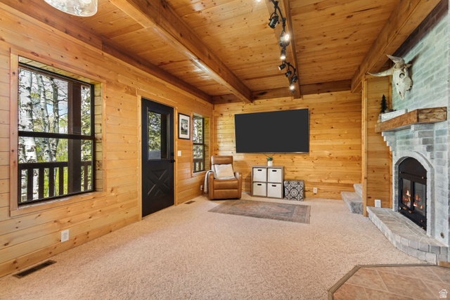11237 East Aspen Road, Unit 74 Heber City, UT 84032 - Photo 6 of 32 Spacious room featuring wood-finish walls and ceiling, a stone-surround fireplace with a wood mantel, and multiple windows