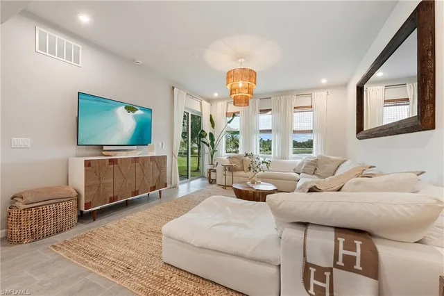 a living room with furniture a large window and a potted plant