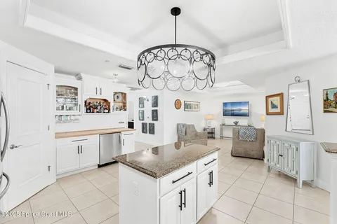 a kitchen with granite countertop cabinets a stove a dining table and chairs