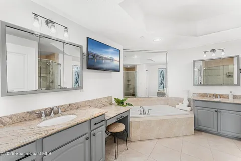 a bathroom with a granite countertop tub sink and mirror