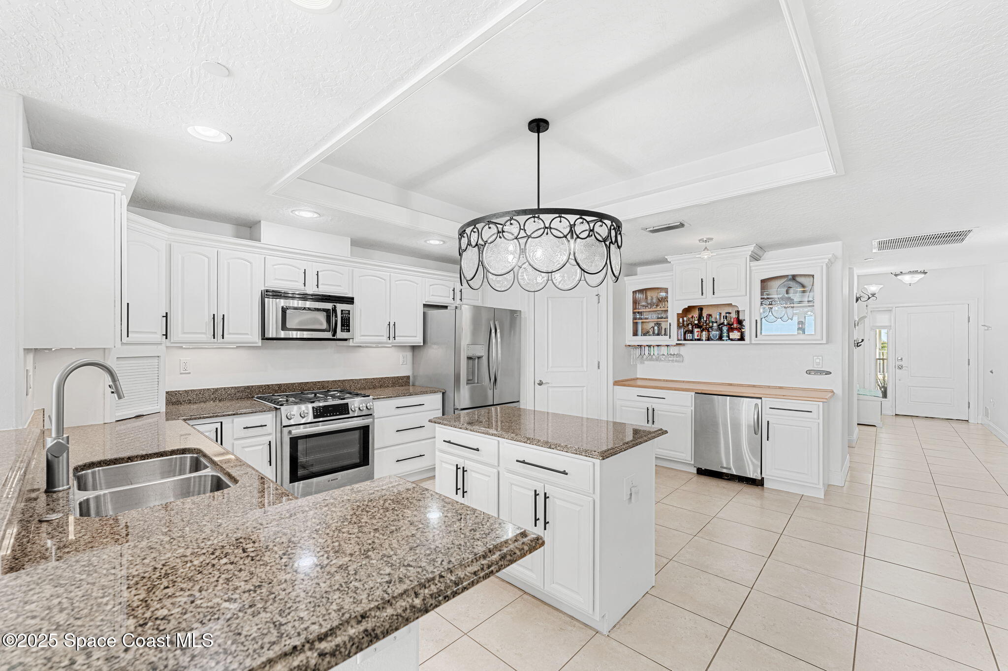 505 South Miramar Avenue, Unit 2403 Indialantic, FL 32903 - Photo 5 of 43 a kitchen with stainless steel appliances granite countertop a stove a sink dishwasher a refrigerator and white cabinets with wooden floor