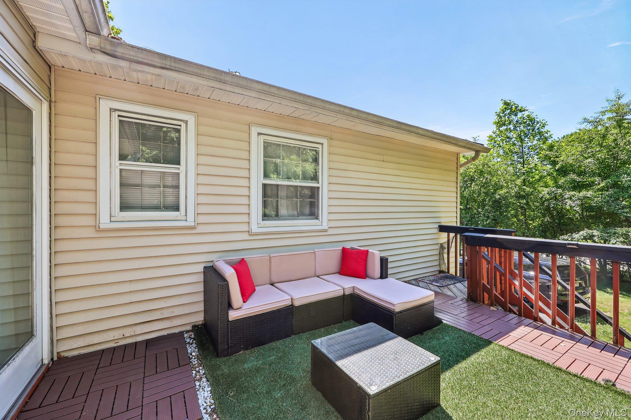 21 Baylor Road Nanuet, NY 10954 - Photo 37 of 44 Expansive outdoor deck featuring wood-finish tile flooring, a slatted wood railing, and a section of artificial turf