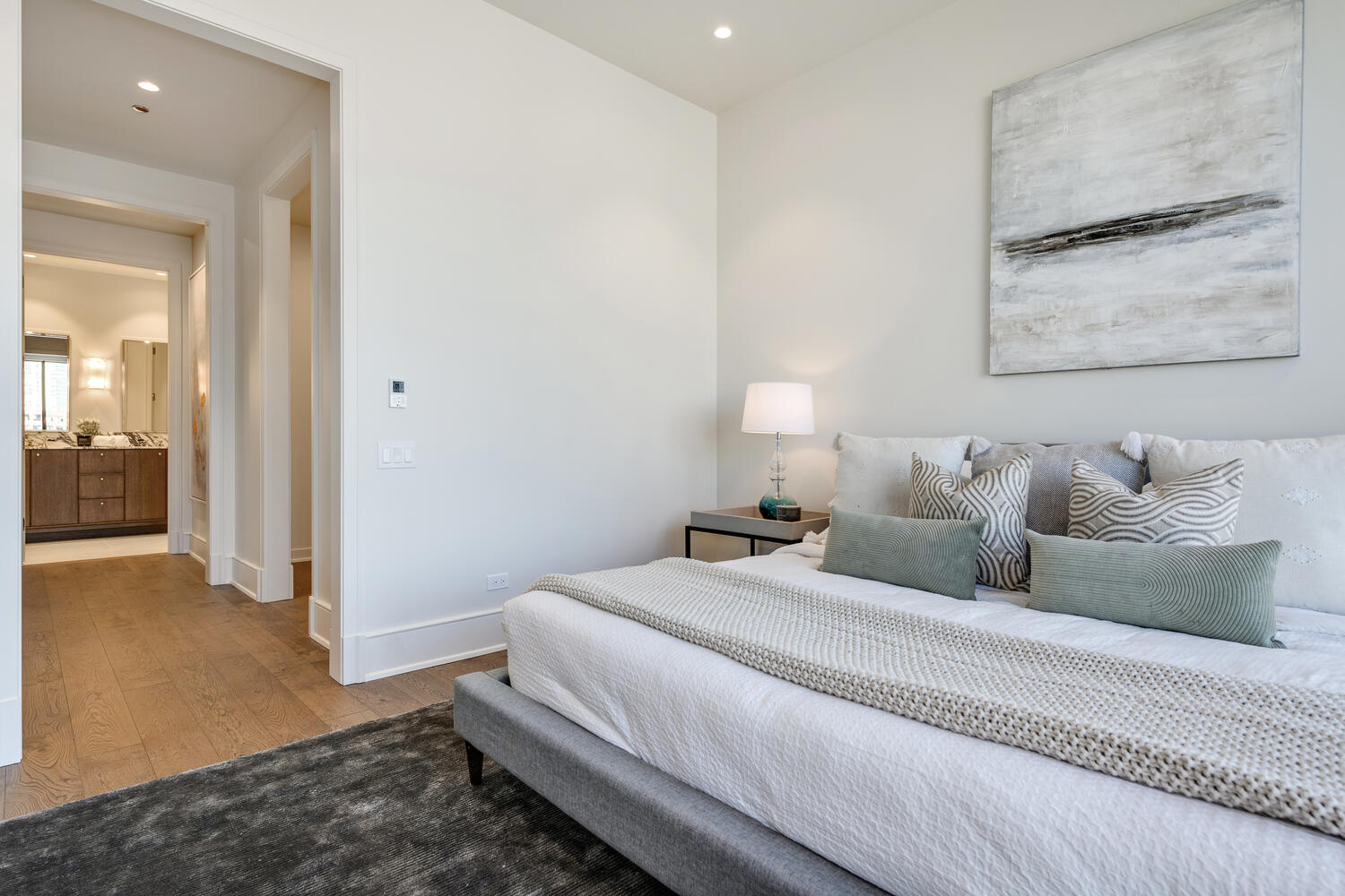 21 North May Street, Unit 1301 Chicago, IL 60607 - Photo 23 of 44 a spacious bedroom with a bed and a painting on the wall