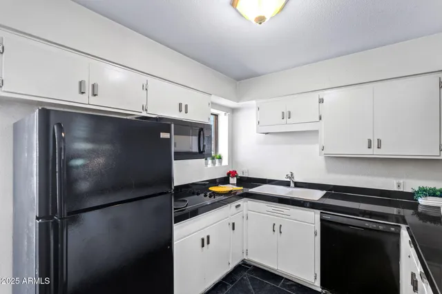 a kitchen with a refrigerator and white cabinets