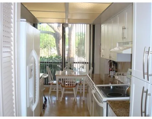 a kitchen with a table chairs and large window