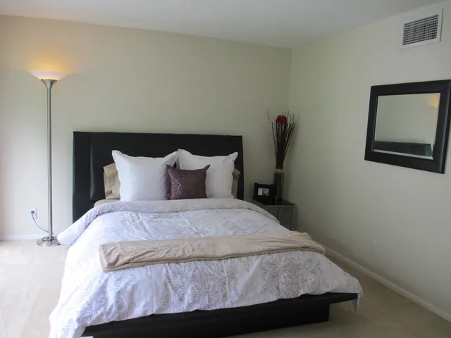a large bed sitting in a bedroom next to a window
