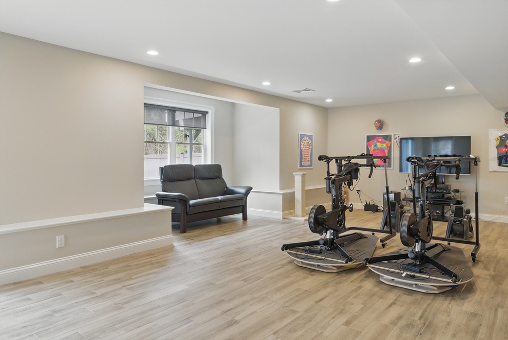 3 Willow Lane Bedford, MA 01730 - Photo 30 of 36 a living room with gym equipment and a wooden floor
