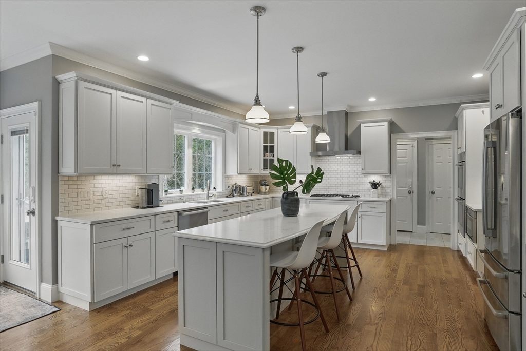 3 Willow Lane Bedford, MA 01730 - Photo 6 of 36 a kitchen with stainless steel appliances kitchen island a chandelier and wooden cabinets