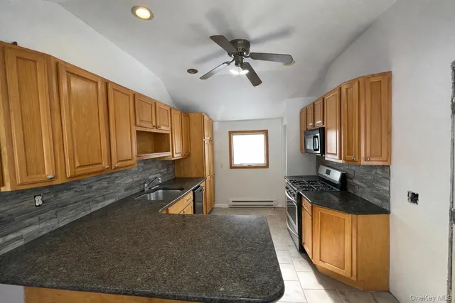 a kitchen with granite countertop cabinets stainless steel appliances a sink and a window