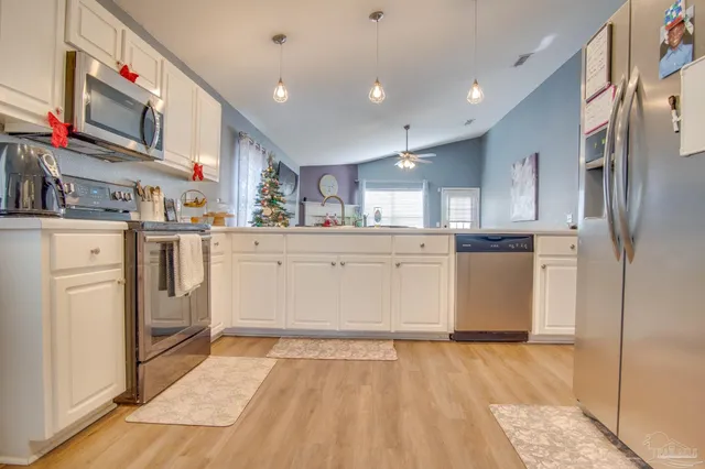 a kitchen with granite countertop a refrigerator and cabinets