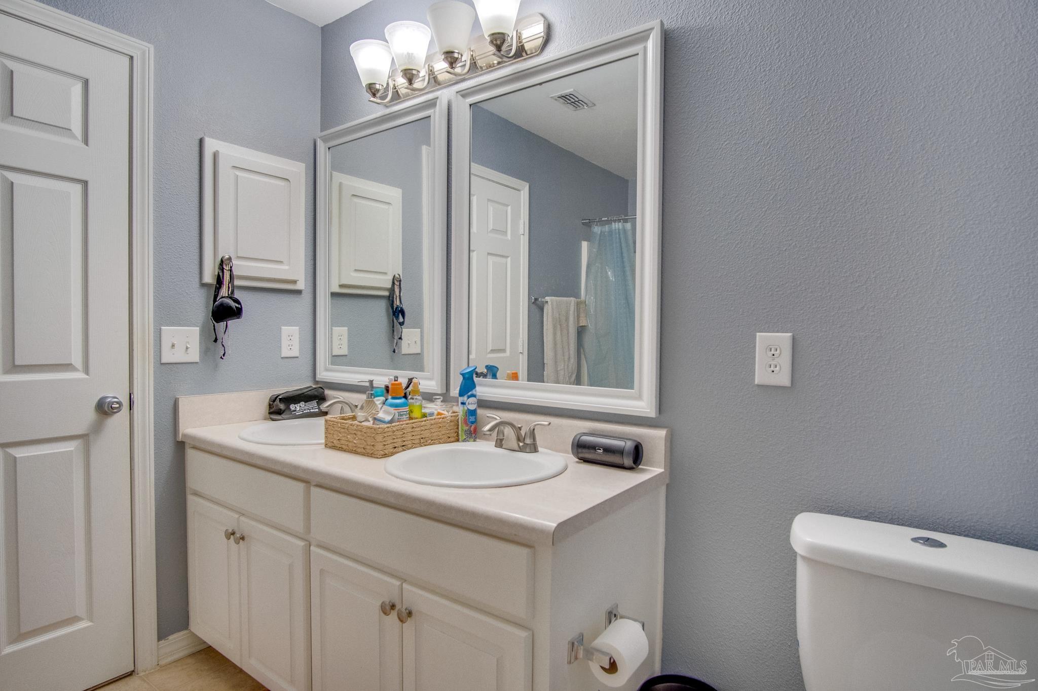 2005 Tujaques Place Pensacola, FL 32505 - Photo 22 of 30 a bathroom with a sink a toilet and a mirror