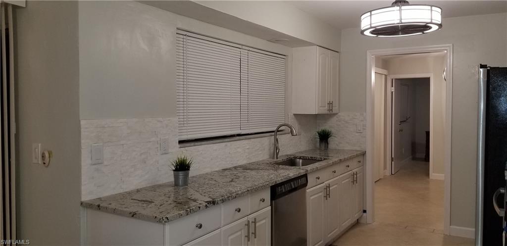 4201 23rd Place Southwest Naples, FL 34116 - Photo 4 of 19 a kitchen with stainless steel appliances granite countertop a sink stove and refrigerator