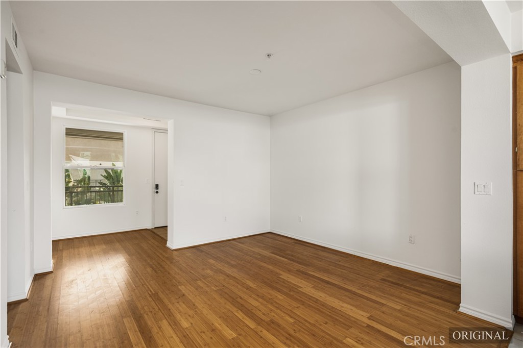85 East Commonwealth Avenue, Unit 3D Alhambra, CA 91801 - Photo 11 of 30 an empty room with wooden floor and windows