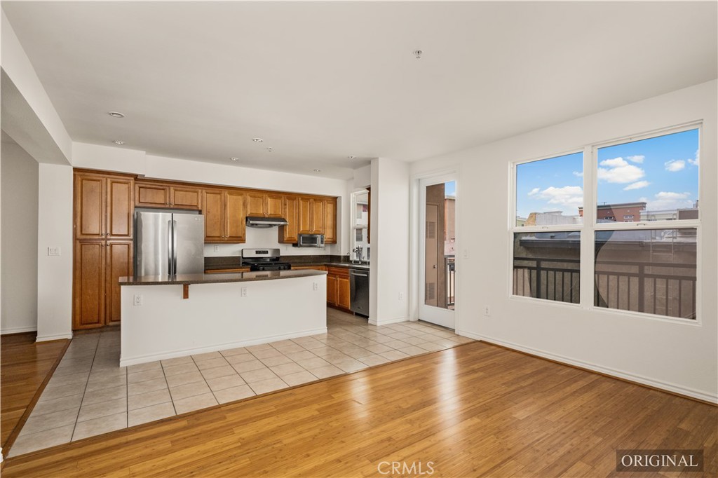 85 East Commonwealth Avenue, Unit 3D Alhambra, CA 91801 - Photo 3 of 30 a large white kitchen with kitchen island a sink wooden floor and stainless steel appliances
