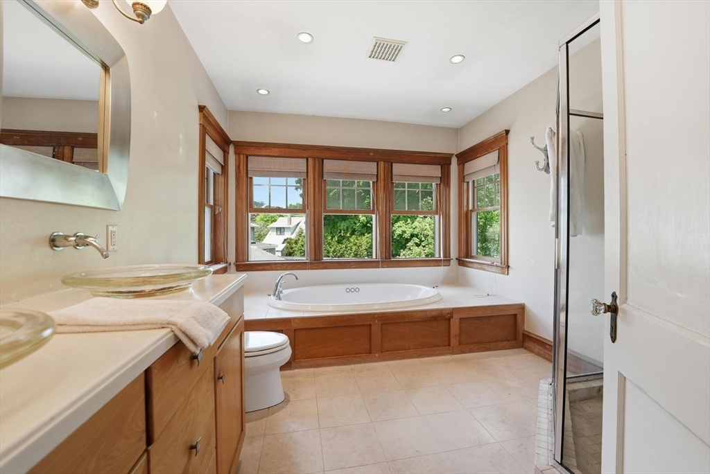 19 Humphrey Street Marblehead, MA 01945 - Photo 20 of 29 a bathroom with a granite countertop sink a large mirror and a bathtub next to a window