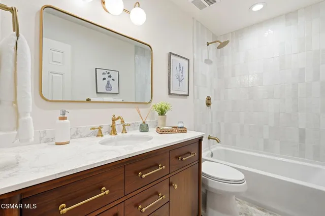 a bathroom with a granite countertop sink a toilet and a bathtub