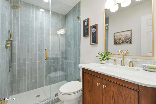 a bathroom with a granite countertop sink toilet and shower