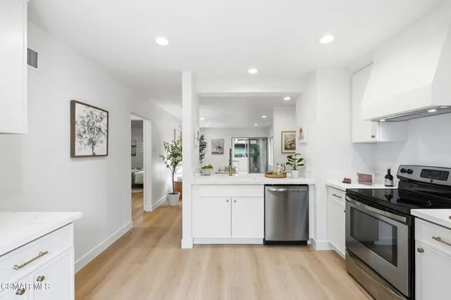 a kitchen with stainless steel appliances a white stove top oven sink and cabinets
