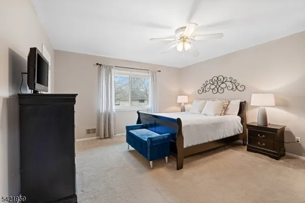 a bedroom with a bed flat screen tv and window