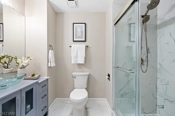 a bathroom with a granite countertop sink toilet and shower