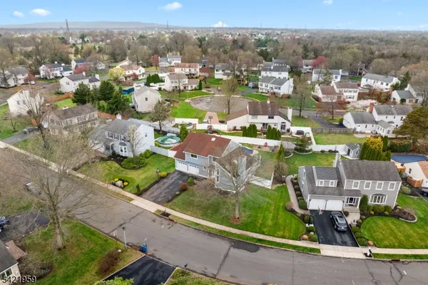 an aerial view of residential houses with outdoor space and parking