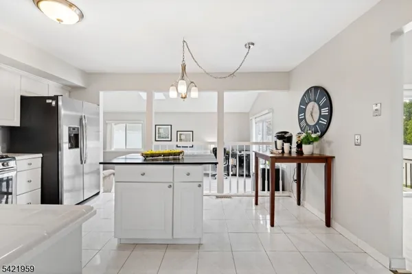 a kitchen with stainless steel appliances a table chairs in it and white cabinets