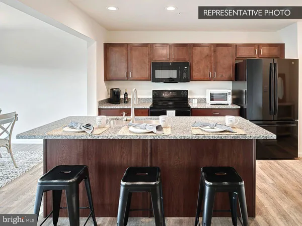 a kitchen with kitchen island a sink stove and refrigerator