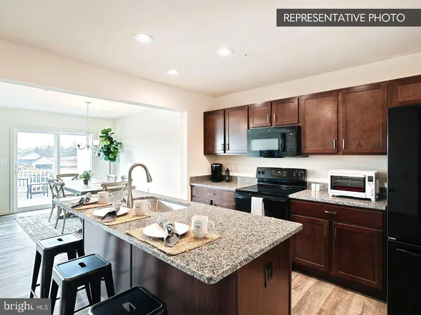 a kitchen with kitchen island granite countertop a sink stove and refrigerator