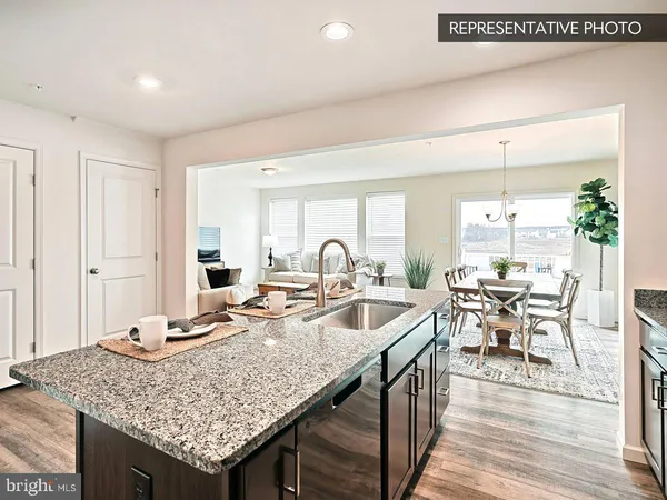 a kitchen with granite countertop a stove and white cabinets