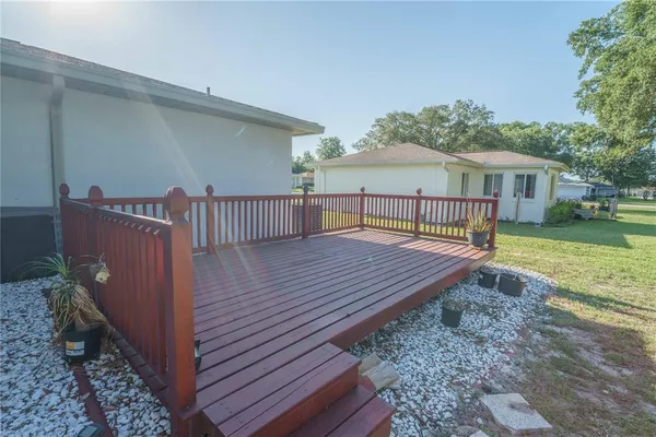 a view of a wooden deck and a yard with the bench