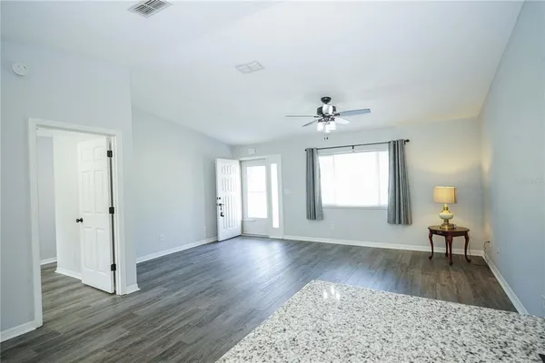 a view of a livingroom with wooden floor and a ceiling fan