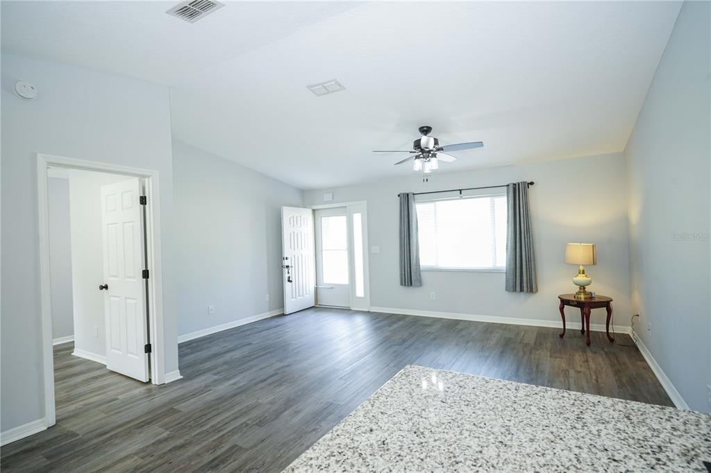 10523 Southwest 62nd Ter Road Ocala, FL 34476 - Photo 4 of 38 a view of a livingroom with wooden floor and a ceiling fan
