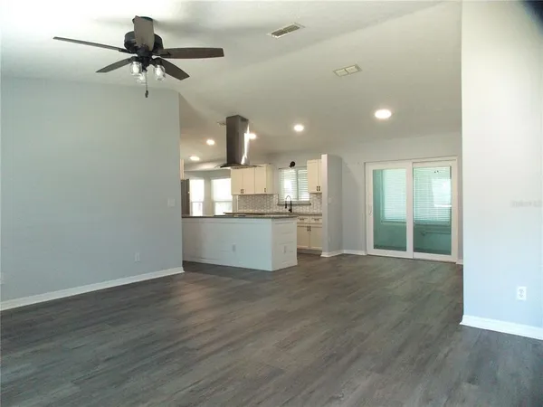 a view of a kitchen with furniture and wooden floor