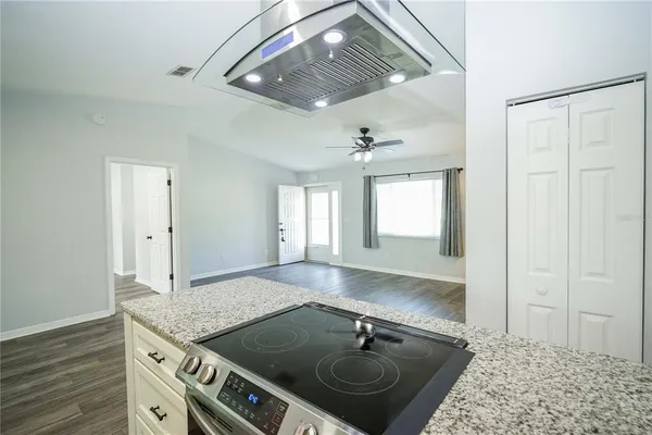 a view of a kitchen sink a stove and wooden floor