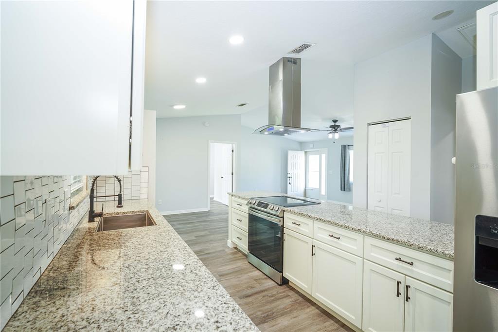 10523 Southwest 62nd Ter Road Ocala, FL 34476 - Photo 8 of 38 a large kitchen with granite countertop a sink stainless steel appliances and cabinets