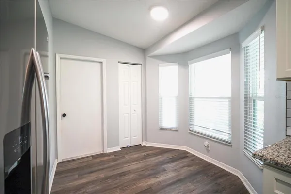 a view of empty room with window and wooden floor