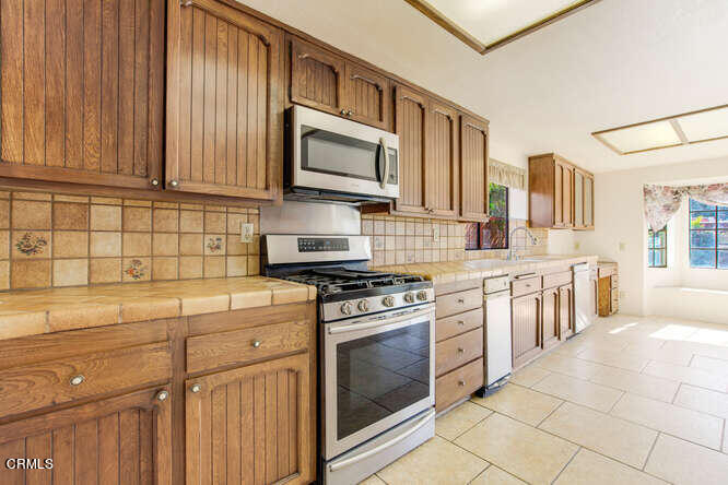 3020 Jacktar Avenue Oxnard, CA 93035 - Photo 9 of 31 a kitchen with stainless steel appliances granite countertop a stove a sink and a microwave