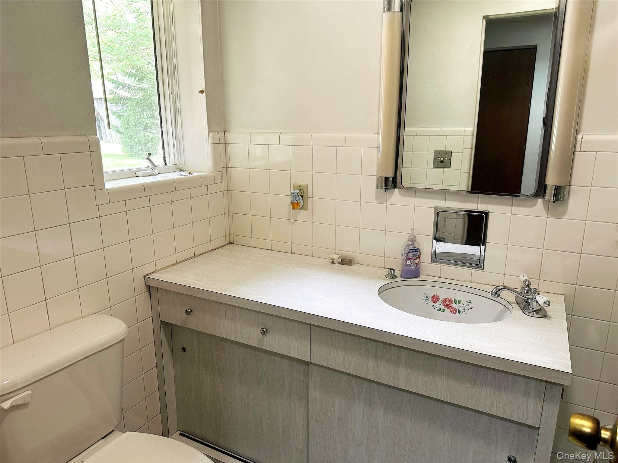 818 Methol Road Roscoe, NY 12776 - Photo 31 of 39 Vintage-style bathroom with updated vanity, original tilework, and natural light.