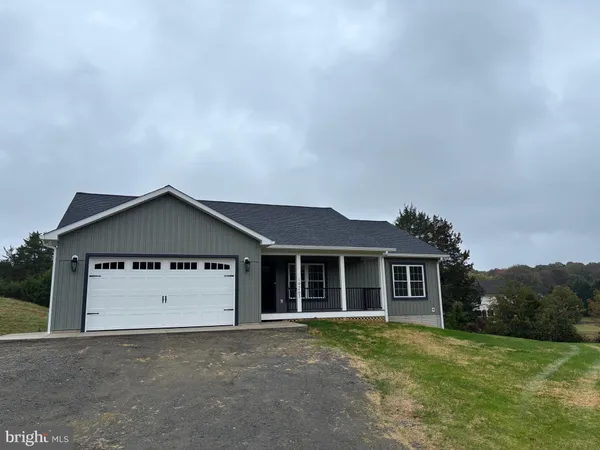 a front view of a house with a garden and yard