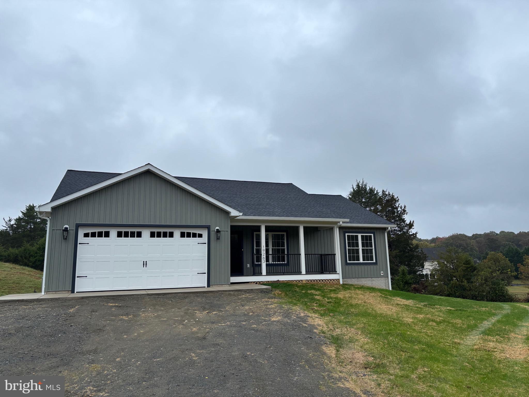 a front view of a house with a garden and yard