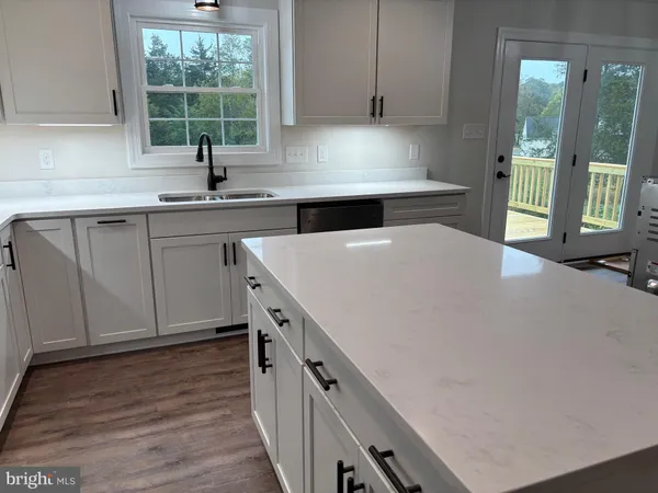 a kitchen with stainless steel appliances a sink a stove and a wooden floors
