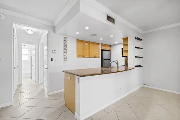a kitchen with stainless steel appliances granite countertop a sink and a refrigerator