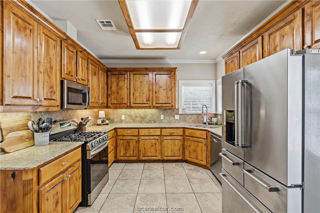 2700 Hickory Court Bryan, TX 77808 - Photo 13 of 31 Granite counters, great sink window, custom alderwood cabinets, stainless appliances & gas stove