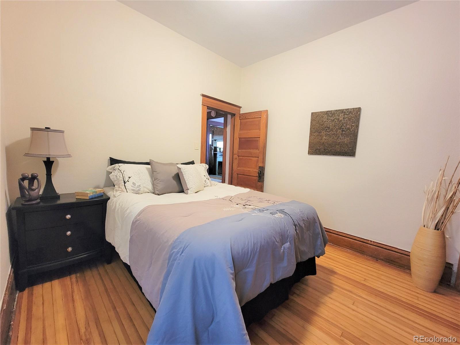 2835 Decatur Street Denver, CO 80211 - Photo 17 of 32 a bedroom with a bed and wooden floor