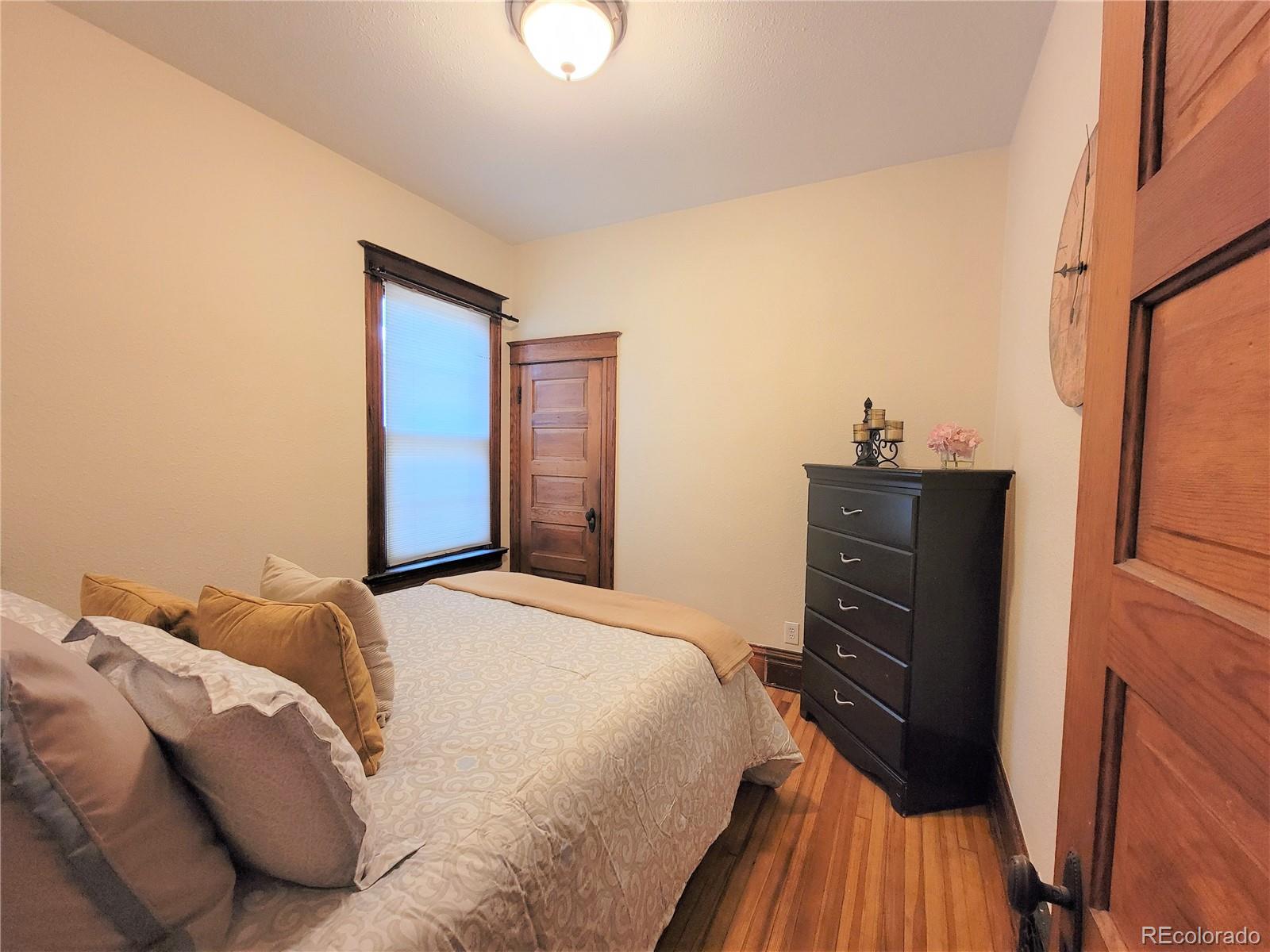 2835 Decatur Street Denver, CO 80211 - Photo 20 of 32 a bedroom with a bed and wooden floor