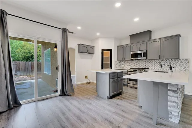 a kitchen with a refrigerator a stove top oven and sink