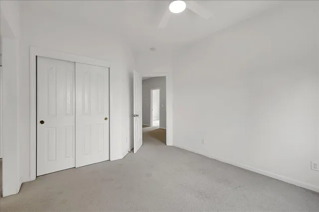 an empty room with a ceiling fan and a window