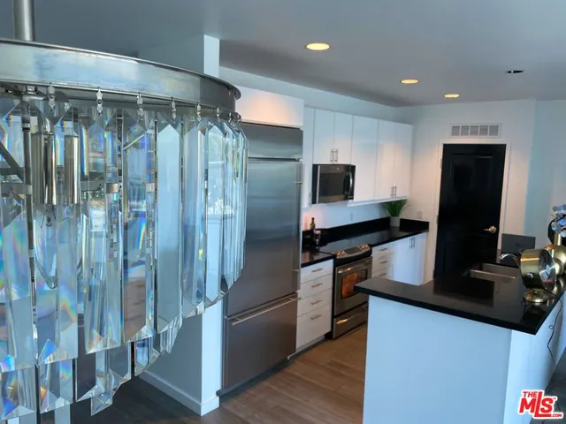 a kitchen with stainless steel appliances granite countertop a refrigerator and a stove top oven