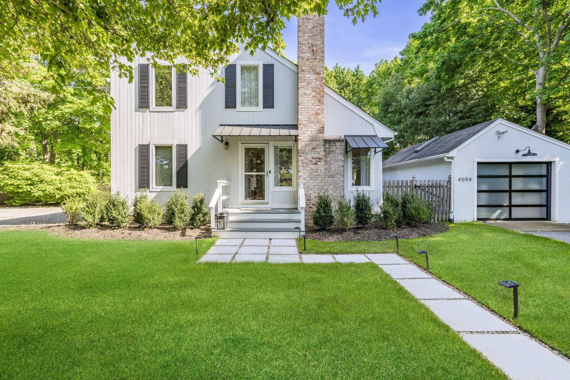 4594 Noyack Road Sag Harbor, NY 11963 - Photo 31 of 31 a front view of a house with a garden and yard